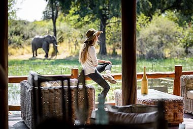 A guest observes an elephant from the deck at Chief's Camp.