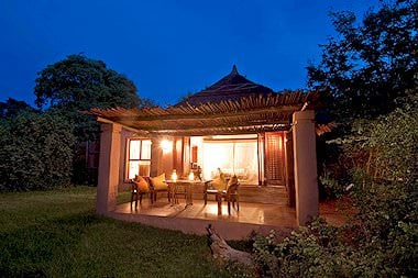 A suite at Chobe Chilwero lit up at night.