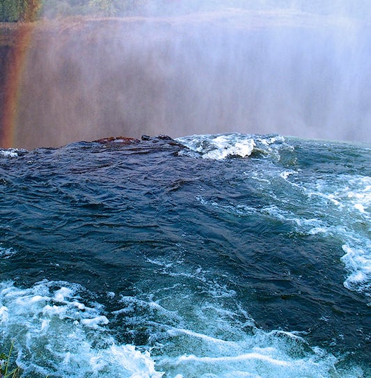 The edge of Devil's Pool at Victoria Falls, looking over the drop into the mist.