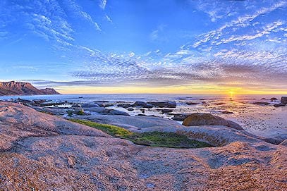 Sunset over rocky tide pools along the coast near Cape Town.