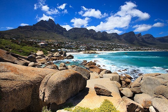 Granite boulders on the shoreline facing the Twelve Apostles mountain range in Cape Town.