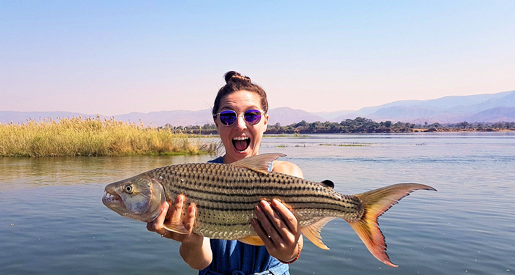 A woman shows off the Tiger Fish she caught in the Zambezi River.