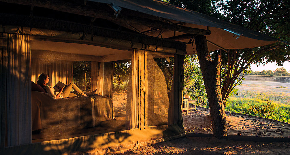 Guest relaxing on a bed at Tena Tena Camp.