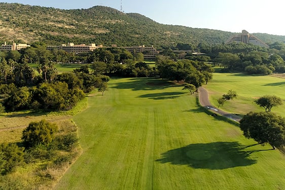 A long fairway bordered by bushveld trees at the Gary Player Country Club in Sun City.