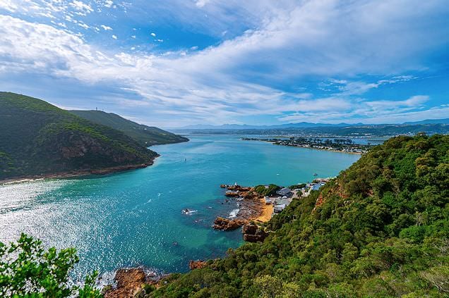 Elevated view of the Knysna Heads channel opening into a lagoon surrounded by green hills.