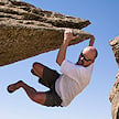 Traveler beneath a granite rock overhang at Vogelfederberg, Namibia.