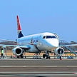 Passenger plane on the tarmac with a light aircraft flying overhead, Kasane Airport, Botswana.
