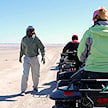 Tour guide briefing guests riding quad bikes across the flat salt pans, Makgadikgadi Pans, Botswana.