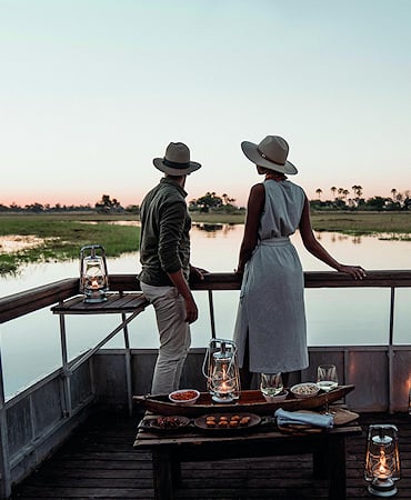 A luxury villa with large glass windows, a wooden deck, and a private pool at Lion Sands Ivory Lodge.