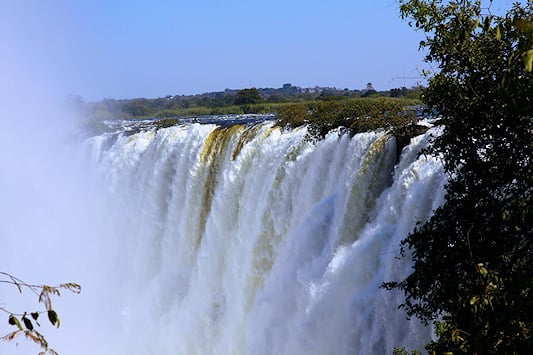 Massive curtain of water falling over the gorge edge, Victoria Falls, Livingstone, Zambia.