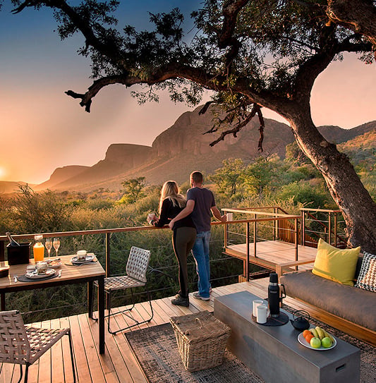 A couple on a luxury safari honeymoon watching the sunset at Marataba in Marakele National Park, South Africa.