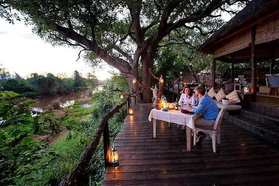 Guests enjoy an early dinner on the deck of Pafuri Camp.