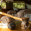 Massage stones, rolled towels, and a candle oil burner prepared for a spa treatment.