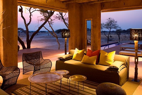 An open-plan safari lounge with a lap pool facing dry savanna plains near Etosha.