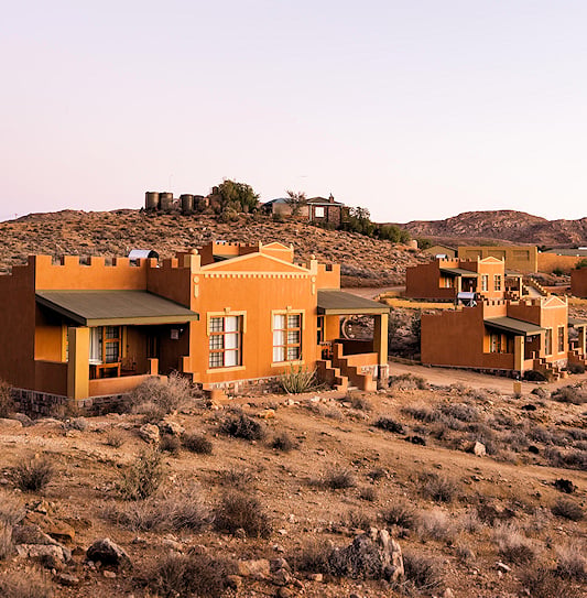 Ochre castle-style units on a hillside near Aus.
