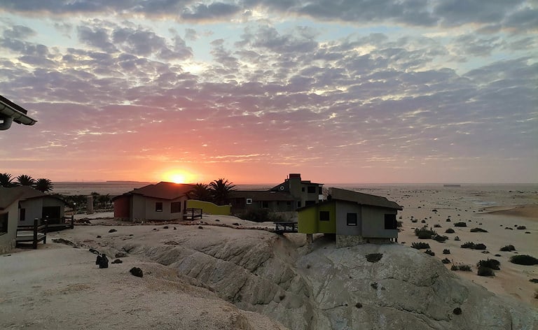 Lodge chalets built on desert ridges overlooking sand dunes at sunset, Desert Breeze Lodge, Swakopmund, Namibia.