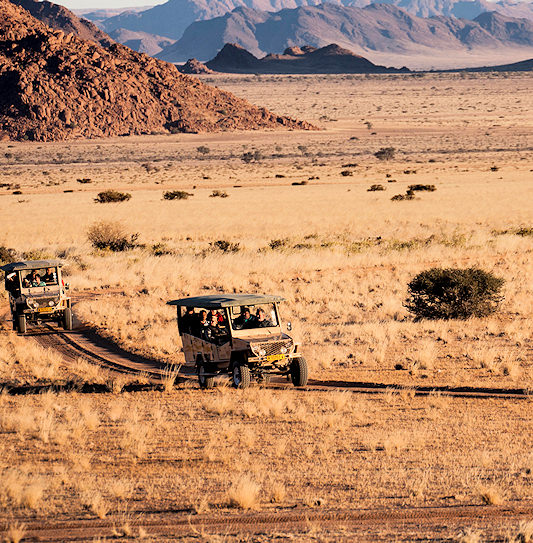 Guests from Sossusvlei Lodge on a sundowner drive through Namib-Naukluft National Park, Namibia.
