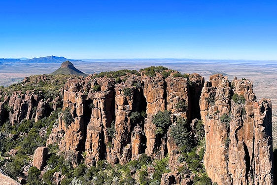 Sheer rock columns and cliffs of the Valley of Desolation looking over open plains.