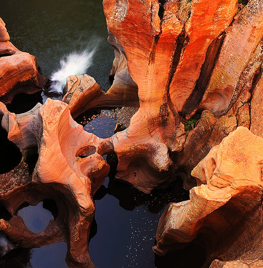 Cylindrical rock potholes carved by water erosion at Bourke's Luck Potholes, Mpumalanga.