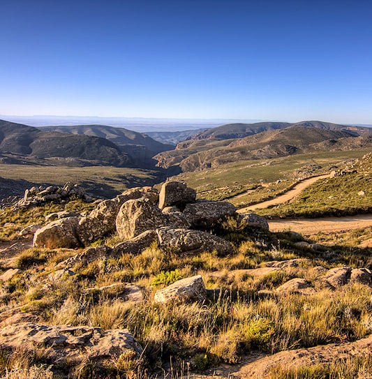 A winding gravel road through the mountains at Swartberg Pass.