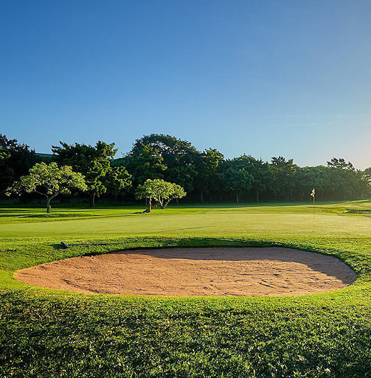 A sand bunker in front of a green beside a small pond in KwaZulu-Natal.