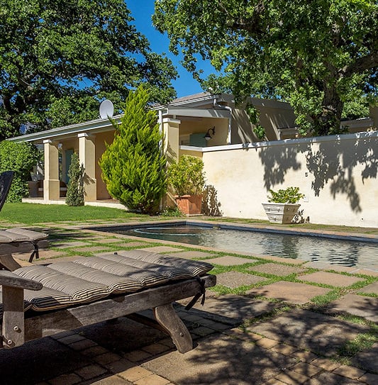 Exterior view of a Cape Dutch style estate building and lawn in Franschhoek.