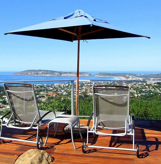 Sun recliners on a wooden balcony overlooking the bay and coastline in the Garden Route.