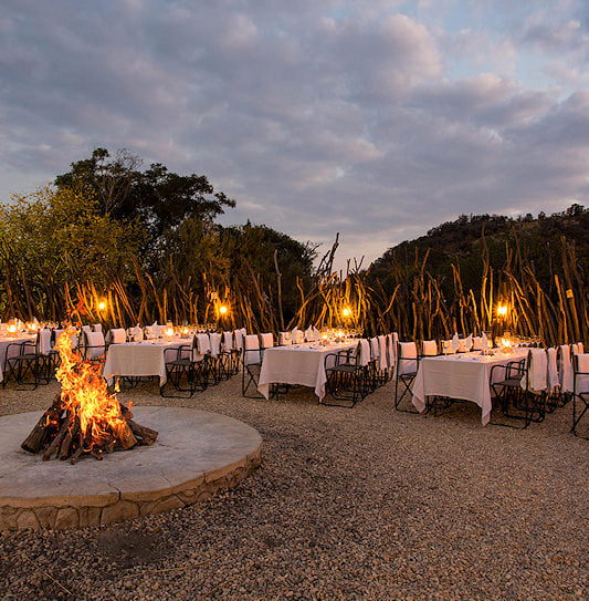 Firelit boma with long dinner tables, Pilanesberg.