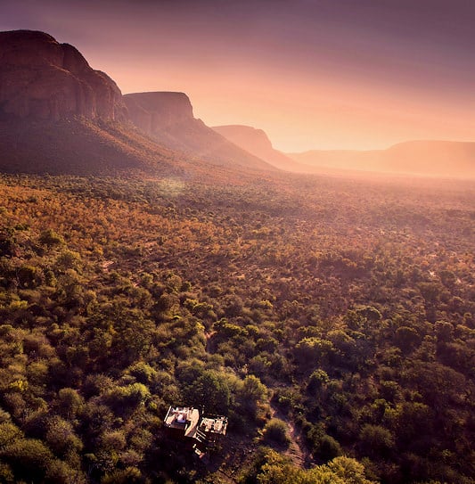 The cliffs of the Waterberg Mountains rising above a valley during sunset in Marakele National Park.