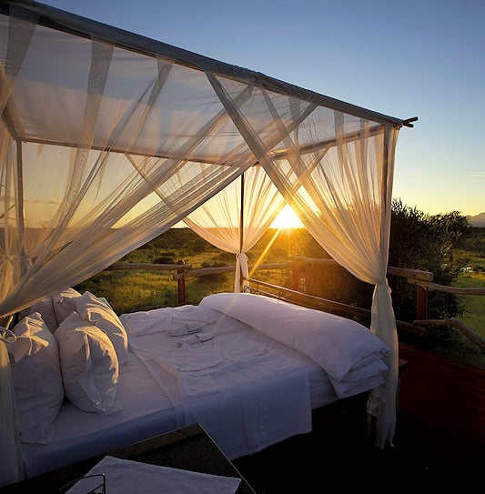 A luxury sleepout bed at sunset in the Kapama Private Game Reserve, South Africa.