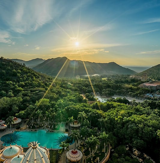 An aerial view of Sun City Resort at sunrise with the Pilanesberg mountains behind.