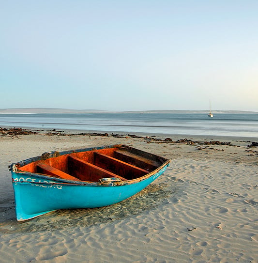A colorful small fishing boat resting on the beach near Paternoster, South Africa.