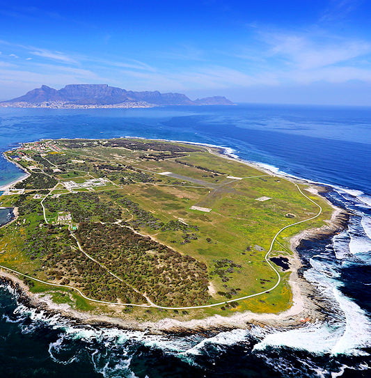 An aerial view of Robben Island with Table Mountain in the background, South Africa.