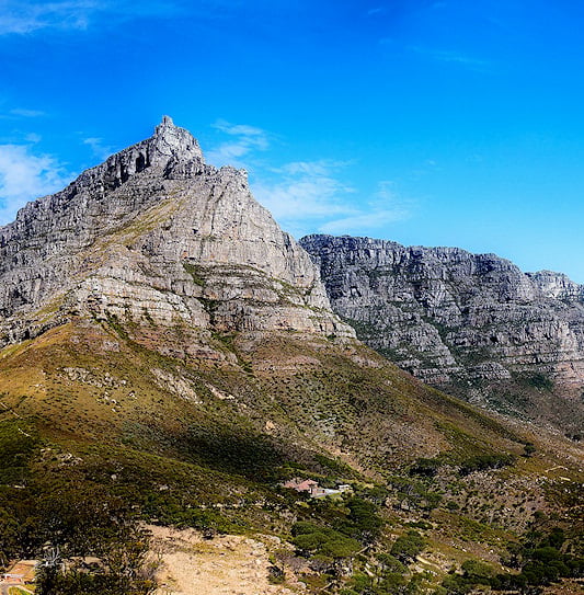 Table Mountain and the Twelve Apostles under a clear blue sky in Cape Town, South Africa.