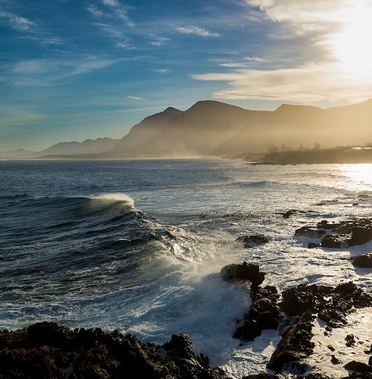 A misty view of the coastline and mountains in Hermanus, South Africa.