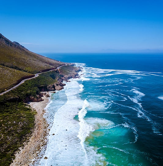 A bird's-eye view of Clarence Drive passing Kogel Bay Beach along the coastline of the Western Cape, South Africa.