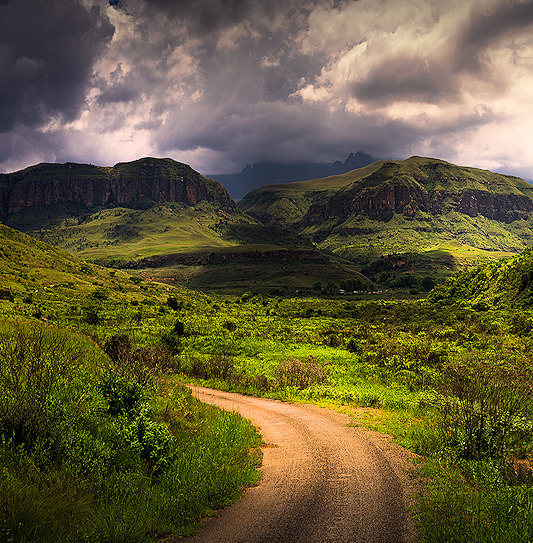 Sunlight breaking through dark rain clouds over the Drakensberg Mountains, KwaZulu-Natal.