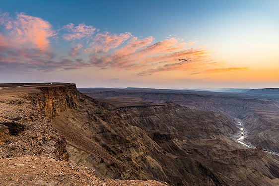High cliff lookout over the expanse of Fish River Canyon at dusk.