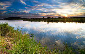 The sun rises over a river in Gonarezhou National Park.