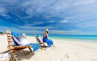 Lady sitting on a beach chair on a tropical shore in Mozambique.